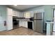 Functional kitchen with stainless steel appliances, white cabinets, and tile flooring at 8436 Magnolia Dr, Jonesboro, GA 30238