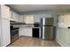 Functional kitchen with stainless steel appliances, white cabinets, and tile flooring at 8436 Magnolia Dr, Jonesboro, GA 30238