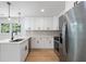 Bright kitchen features stainless steel appliances, white cabinets, and an eat-in kitchen island at 1409 Georgia Ave, East Point, GA 30344