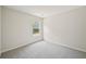 Empty bedroom with neutral carpet and walls, and a window overlooking trees at 231 Silver Fox Trl, Dallas, GA 30157