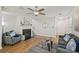 Cozy living room with a fireplace, wood floors, a ceiling fan, and modern furniture at 231 Silver Fox Trl, Dallas, GA 30157