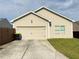 Exterior view of a beige one-story home with attached garage, driveway, and small front yard at 2979 Dungeness Dr, Douglasville, GA 30135