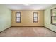 Empty bedroom with beige walls and carpet, and three windows providing natural light at 338 Patterson Rd, Lawrenceville, GA 30044