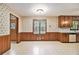 Empty kitchen area with wood cabinets, white counters, vinyl floors, and an adjacent eating area at 338 Patterson Rd, Lawrenceville, GA 30044