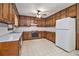 Kitchen showcasing wood cabinets, white appliances, vinyl floors, and a functional layout at 338 Patterson Rd, Lawrenceville, GA 30044