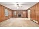 Spacious living room features wood paneling, brick fireplace, and a ceiling fan at 338 Patterson Rd, Lawrenceville, GA 30044
