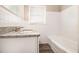 Bright bathroom with granite countertops, white tile, and a clean, updated bathtub at 41 Elder St, Fairburn, GA 30213