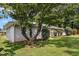 View of the charming one-story home with a lush green lawn and mature trees in the yard at 41 Elder St, Fairburn, GA 30213