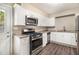 Well-lit kitchen boasts stainless steel appliances, granite countertops, and modern white cabinetry at 41 Elder St, Fairburn, GA 30213