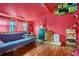 Unique bedroom features pink walls, wood floors, futon, and shelves at 1198 Old Mill Rd, Dallas, GA 30157