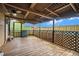 Covered porch with ceiling fan and latticework overlooks backyard and sky at 1198 Old Mill Rd, Dallas, GA 30157