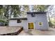 Back exterior featuring gray siding, a sliding glass door, stone chimney and a small patio at 733 Emerald Forest Cir, Lawrenceville, GA 30044
