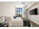 Bright bedroom with a ceiling fan, window with treeline views, and mounted TV at 905 Juniper Ne St # 805, Atlanta, GA 30309
