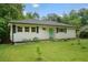 This lovely ranch-style home boasts a well-manicured lawn and features black shutters and a modern green front door at 2049 Rector Dr, Atlanta, GA 30311