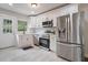 The modern kitchen features stainless steel appliances, white cabinetry, and white tiled floors at 2049 Rector Dr, Atlanta, GA 30311