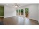 Sun-filled living room with gleaming hardwood floors, a ceiling fan, and sliding glass doors to a deck at 2049 Rector Dr, Atlanta, GA 30311