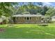 Grassy backyard featuring a brick house with a covered porch and a grill at 2483 Hunting Valley Dr, Decatur, GA 30033