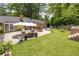 Inviting backyard featuring a brick patio with seating, a fire pit, a lush lawn, and mature trees at 2658 Briarlake Ne Rd, Atlanta, GA 30345
