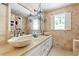 Luxurious bathroom featuring dual bowl sinks, stone tile walls, and charming sconce lighting at 2658 Briarlake Ne Rd, Atlanta, GA 30345