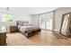 Bright bedroom featuring hardwood floors, neutral tones, and a comfortable queen-sized bed with backyard views at 2658 Briarlake Ne Rd, Atlanta, GA 30345