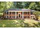 Inviting brick home featuring a white-columned front porch and mature landscaping for enhanced curb appeal at 2658 Briarlake Ne Rd, Atlanta, GA 30345