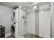 Bathroom featuring a glass enclosed shower and tiled wall accents, with a washer and dryer at 3048 Briarcliff Ne Rd # 9, Atlanta, GA 30329