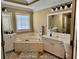 Spacious bathroom with tub, tiled floors, and cabinets at 3310 Mcclure Woods Ct, Duluth, GA 30096