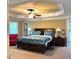Comfortable main bedroom with tray ceiling, a fan, and an en-suite bathroom at 3310 Mcclure Woods Ct, Duluth, GA 30096