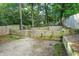 Backyard featuring a tiered wooden retaining wall, lush foliage, and privacy fence at 727 Holmes Nw St, Atlanta, GA 30318