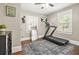 Cozy bedroom featuring a treadmill, area rug, and natural light from two windows at 727 Holmes Nw St, Atlanta, GA 30318