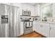 Bright kitchen features stainless steel appliances, white cabinets, and hardwood floors at 727 Holmes Nw St, Atlanta, GA 30318