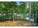 Lush backyard view, showing mature trees, lake access, and a private dock, offering a serene waterfront retreat at 1525 Lockridge Dr, Cumming, GA 30041