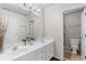 Bathroom featuring a double sink vanity with white countertops, a large mirror, and access to a separate toilet room at 1525 Lockridge Dr, Cumming, GA 30041
