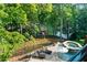Backyard oasis with a pool, lounge chairs, umbrella, spa, and lush trees providing privacy at 1525 Lockridge Dr, Cumming, GA 30041