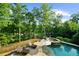 Backyard features a luxurious pool and hot tub, surrounded by lounge chairs and lush greenery at 1525 Lockridge Dr, Cumming, GA 30041