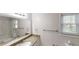 Bright bathroom featuring a granite countertop, a large mirror, and ample natural light through the window at 3136 Palomino Dr, Powder Springs, GA 30127