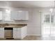 Bright kitchen with white cabinetry, stainless steel dishwasher and view of backyard at 3136 Palomino Dr, Powder Springs, GA 30127