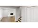 A bright hallway with wooden floors, adjacent to a living room with a white-painted brick fireplace at 3695 Fox Hills Se Dr, Marietta, GA 30067
