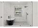Bright bathroom featuring a sleek black soaking tub, glass shower, and modern fixtures against white marble tiling at 90 Mckown Rd, Fayetteville, GA 30214