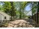 Backyard featuring a large driveway, a tree-lined border, and a peek at the home at 1472 Norman Berry Dr, Atlanta, GA 30344