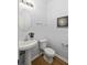 Half bathroom features a pedestal sink, round mirror, and modern fixtures at 4457 Watson Ridge Dr, Stone Mountain, GA 30083