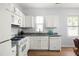 Bright kitchen featuring white cabinets, modern appliances, granite countertops, and hardwood floors at 4457 Watson Ridge Dr, Stone Mountain, GA 30083