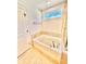 Bright bathroom with a soaking tub and neutral tile surround, adjacent to the shower at 5599 Wheeler Ridge Rd, Auburn, GA 30011