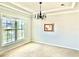 Bright, carpeted dining room with a large window and elegant chandelier, perfect for Gathering meals at 5599 Wheeler Ridge Rd, Auburn, GA 30011