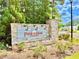 A stone community entrance sign with lush landscaping on a sunny day at 5599 Wheeler Ridge Rd, Auburn, GA 30011