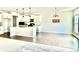 Bright kitchen with white cabinets, a large island, and hardwood floors flowing into an adjacent living area at 5599 Wheeler Ridge Rd, Auburn, GA 30011