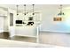 Bright kitchen with white cabinets, a large island, and hardwood floors flowing into an adjacent living area at 5599 Wheeler Ridge Rd, Auburn, GA 30011