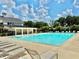 A large community pool with lounge chairs is surrounded by mature trees on a sunny day at 5599 Wheeler Ridge Rd, Auburn, GA 30011
