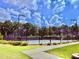 A fenced community tennis court is surrounded by lush greenery and sidewalks at 5599 Wheeler Ridge Rd, Auburn, GA 30011