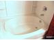 White bathtub with chrome fixtures and a shower head in a tiled alcove at 5626 Laurel Ridge Dr, Atlanta, GA 30344
